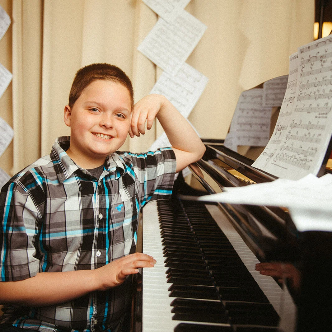 A Boy Sitting in Front of a Piano